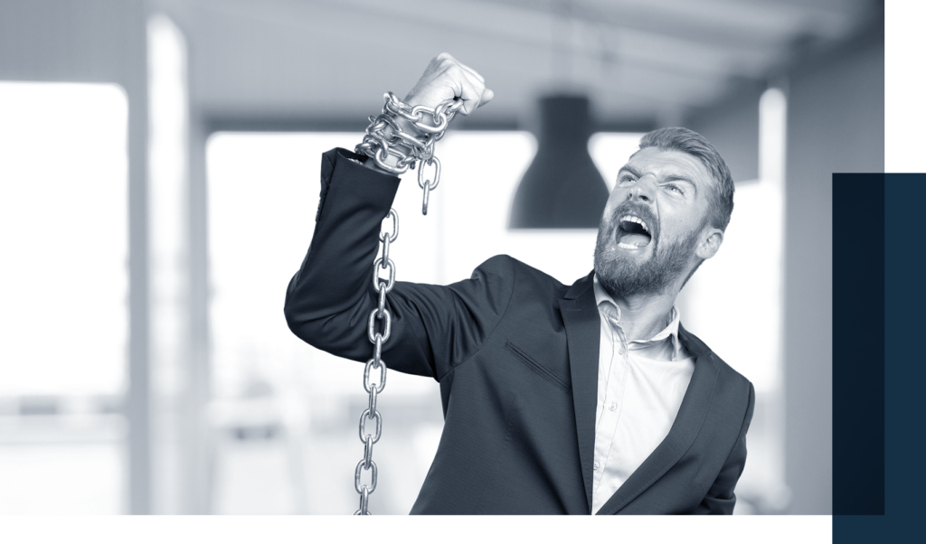 Furious man in a suit trying to raise a chained arm