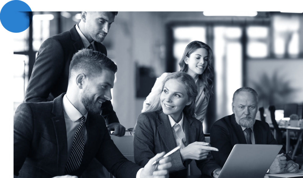 Team of seated and standing consultants collaborating while pointing at a screen