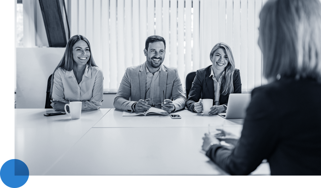 Happy team across table from a new team member