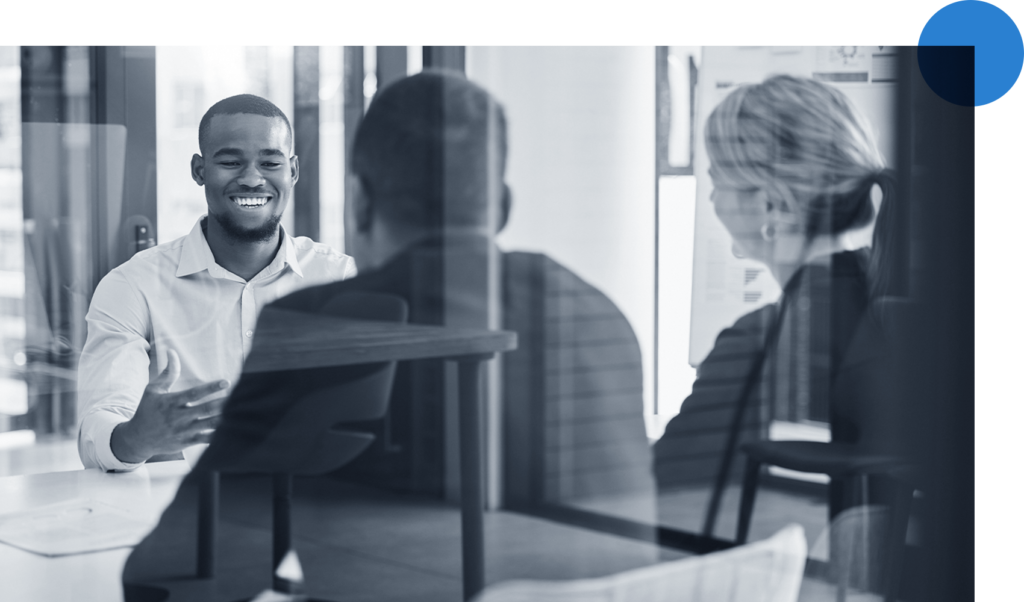 Three happy people meeting in an all glass conference room