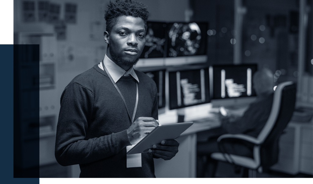 cybersecurity analyst holding a tablet looking up